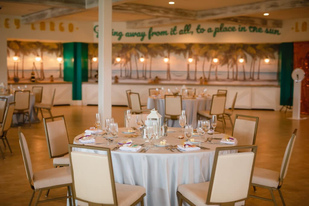 wedding reception with white tables and cream chairs in modern casual space - margaritaville resort orlando wedding venue